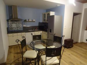 a kitchen with a glass table and chairs in it at Gite De Ségonzac in Villecomtal