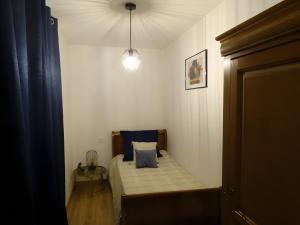 a small bedroom with a bed with a blue pillow at Gite De Ségonzac in Villecomtal