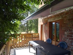 a patio with a table and chairs on a deck at Gite De Ségonzac in Villecomtal +4 photos