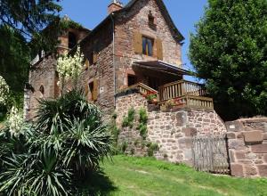 an old stone house with a balcony on a hill at Gite De Ségonzac in Villecomtal