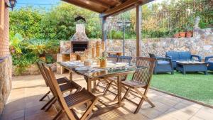 a patio with a table and chairs and a fireplace at Costacabana - Villa Alba in Lloret de Mar
