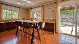 a kitchen with a wooden table and bar stools at Costacabana - Villa Alba in Lloret de Mar