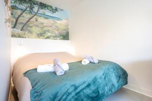 two stuffed animals sitting on top of a bed at La pause iodée Studio -grand balcon in Concarneau