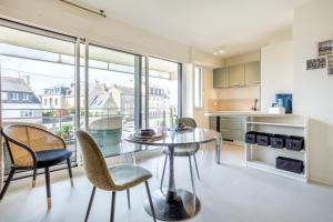 a dining room with a glass table and chairs at La pause iodée Studio -grand balcon in Concarneau