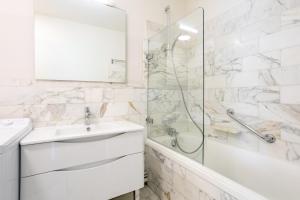 a white bathroom with a sink and a shower at La pause iodée Studio -grand balcon in Concarneau +14 photos