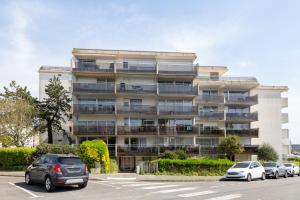 a large building with cars parked in a parking lot at La pause iodée Studio -grand balcon in Concarneau