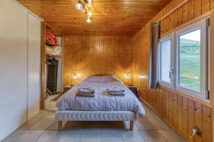 a bedroom with a bed in a wooden wall at Appartamento In Chalet in Murianette