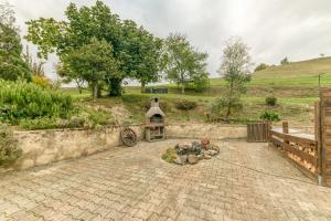 a stone patio with a fire pit in a garden at Appartamento In Chalet in Murianette