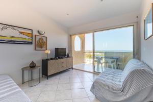 a bedroom with a bed and a tv and a balcony at Marina de Sant Ambroggio in Lumio