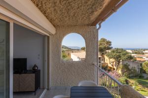 a balcony with an arched window with a view at Marina de Sant Ambroggio in Lumio