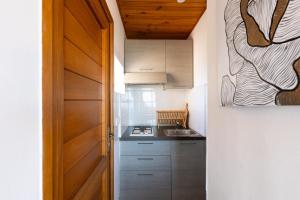a small kitchen with a sink and a door at Marina de Sant Ambroggio in Lumio