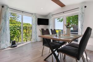 a dining room with a table and chairs and windows at Haus Waldblick in Saal