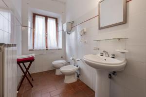 a white bathroom with a sink and a toilet at Appartamento Glicine in Radicofani +13 photos