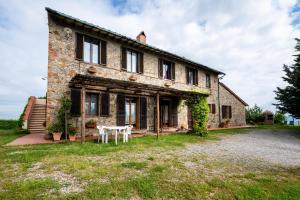 an old stone house with a table in front of it at Appartamento Glicine in Radicofani