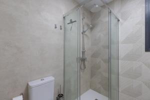 a bathroom with a glass shower with a toilet at Victoria's Apartamentos Beach in Málaga +14 photos