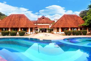 a large swimming pool in front of two buildings at KTDC Bolgatty Palace & Island Resort in Cochin