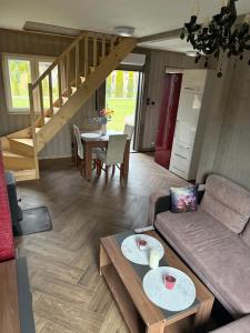 a living room with a couch and a table at Bajkowe Domki Marzeń Grei in Węgorzewo