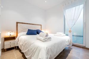 a bedroom with a large bed with towels on it at Mabicarent Playa 1 in Calafell