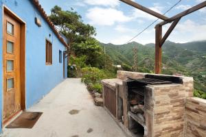 a stone fireplace in a house with mountains in the background at Casa Azul del Roque Negro in Santa Cruz de Tenerife