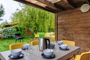 a table with plates and cups on it on a patio at Chalet prestige 19 piscine partagée in Saint-Gervais