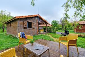 a deck with chairs and a table and a cabin at Chalet prestige 19 piscine partagée in Saint-Gervais