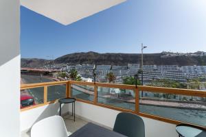 a balcony with chairs and a view of a city at Casa Neale in Puerto Rico de Gran Canaria