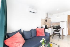 a living room with a blue couch with pink pillows at Casa Neale in Puerto Rico de Gran Canaria