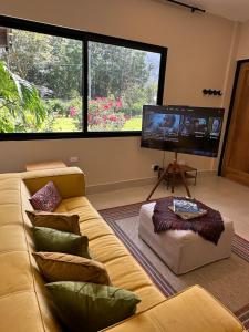 a living room with a couch and a flat screen tv at Casa Makuira 2 in El Valle de Antón