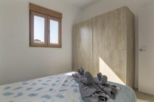 a bedroom with a bed with a towel on it at Casa Sofia in Conil de la Frontera +19 photos