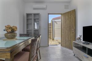 a dining room with a table and a television at Casa Sofia in Conil de la Frontera