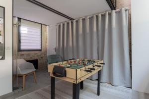 a foosball table in a room with a curtain at Bocal De Bages - Chez l'habitant in Bages