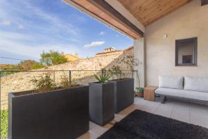 a patio with a couch on a balcony at Bocal De Bages - Chez l'habitant in Bages