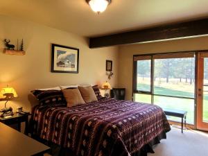 a bedroom with a bed and a large window at 89 Meadow House in Sunriver +25 photos