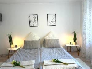 Un dormitorio blanco con una cama con dos mesas. en Apartment Alb Glück 1, en Hechingen