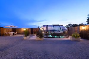 a glass dome sitting in a yard with potted plants at L'Ascalon in Saint-Sauveur-le-Vicomte