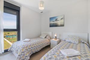 two beds in a bedroom with a window at Los Flamencos in Isla Canela +23 photos