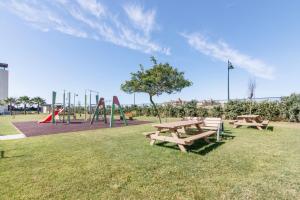 a park with three picnic tables and a playground at Los Flamencos in Isla Canela