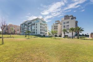 two tall buildings in a park with a grass field at Los Flamencos in Isla Canela