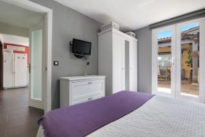 a bedroom with a bed and a tv on a wall at La Suerte viviendas in Agaete