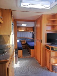 a small room with a tv and a kitchen at Roca Caravan in Estepona