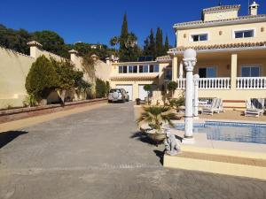 a house with a car parked in front of a driveway at Roca Caravan in Estepona