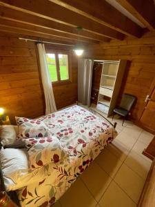 a bedroom with a bed in a log cabin at Le Chalet de Noblat in Saint-Léonard-de-Noblat