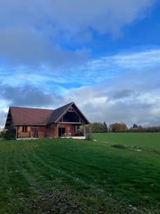 a barn in a field with a green field at Le Chalet de Noblat in Saint-Léonard-de-Noblat