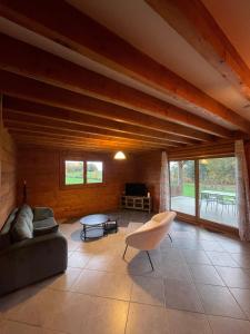 a living room with a couch and a table at Le Chalet de Noblat in Saint-Léonard-de-Noblat