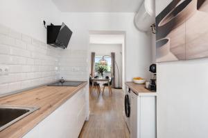a kitchen with white walls and wooden floors and a table at Ula Home in Barbate