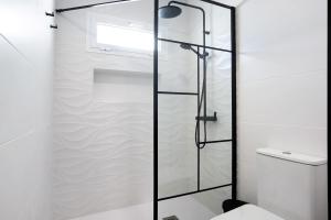 a glass shower door in a bathroom with a toilet at Ula Home in Barbate +14 photos