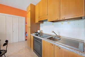 a kitchen with wooden cabinets and a sink at vista lago apartment 2 in Soiano del Lago