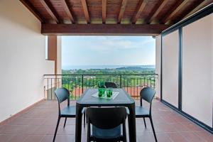 a dining room with a table and chairs on a balcony at vista lago apartment 2 in Soiano del Lago