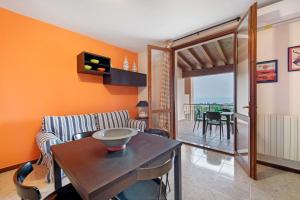 a living room with orange walls and a table and chairs at vista lago apartment 2 in Soiano del Lago