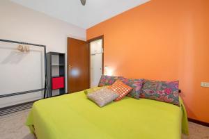 a bedroom with a green bed with pillows on it at vista lago apartment 2 in Soiano del Lago +19 photos